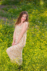 Beautiful young girl among yellow flowers