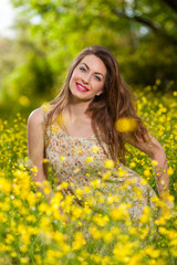 Naklejka na ściany i meble Beautiful young girl among yellow flowers