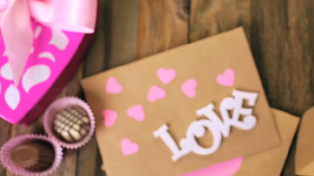 Chocolates in heart shaped box on rustic wood table