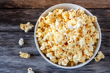 Popcorn in  bowl over on wooden background