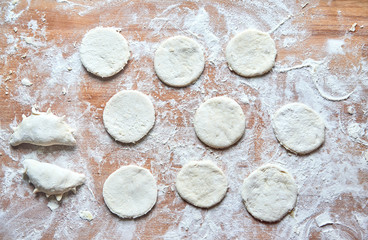 Raw floured dough on wooden table