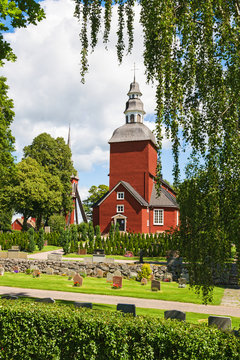 Cemetery with a red Wooden Church