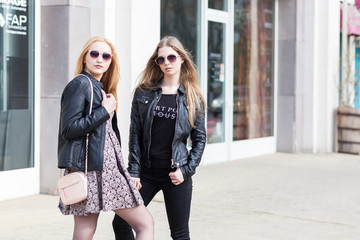 Girl in leather jackets and sunglasess posing outside