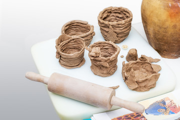 Many amateur handmade unbaked clay moldings and rolling-pin