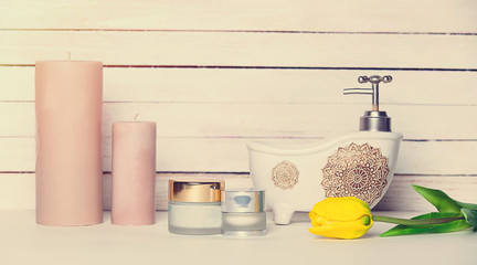 tulip, cosmetics and candles lying on the table