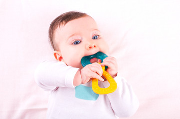 Baby girl with rattle teether toy. 