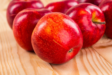 Ripe red apples on wooden background