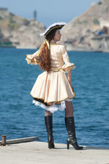 Young woman in pirate costume on pier