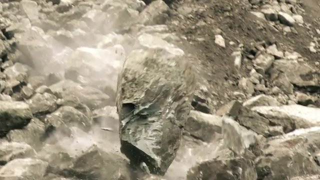 Experience the breathtaking slow motion tracking shot of a massive boulder dramatically descending in front of the camera.