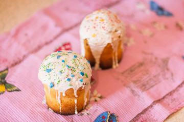 Two easter cakes on pink towel and pink background