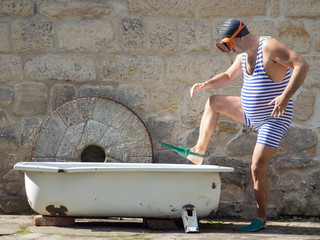Man with snorkeling gear going to the bathtub outdoor