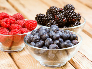 blueberries blackberries and raspberries in glass bowl