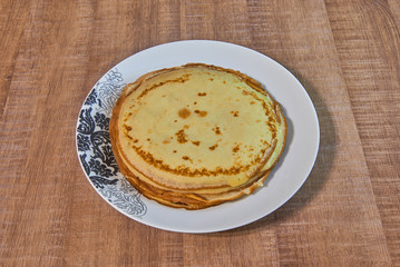 Pancakes with honey on white plate.