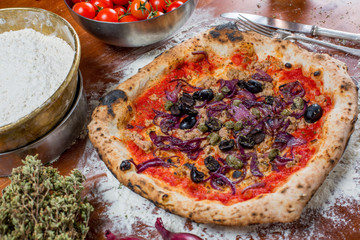 Traditional italian pizza with tuna, onions, caper and olives, o