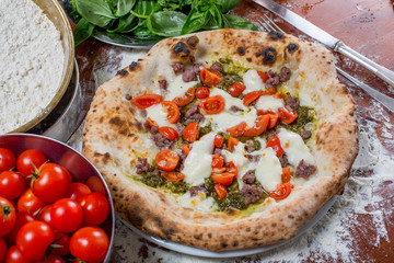 Italian traditional pizza with mozzarella, sausage, tomato and p
