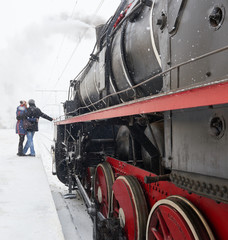 Couple embracing on platform near steam locomotive