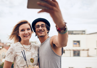 Two young friends taking self portrait at party