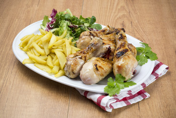 Pollo a la brasa con patatas fritas y ensalada
