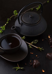 Obraz na płótnie Canvas Chocolate candy with tea and teapot