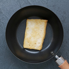 Tofu frit dans une poêle sur ardoise