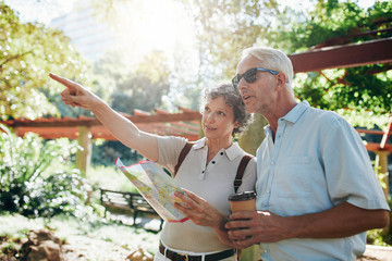 Couple of senior tourists using a city map