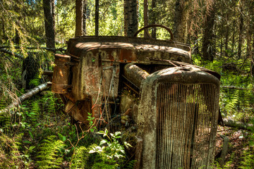 Fototapeta premium Old tractor abandoned in the woods