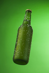 Bottle of ice cold beer with ice and drops