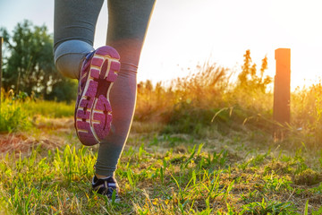 Woman running at sunset in a field