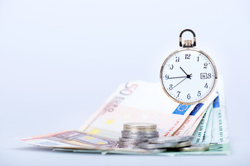 pocket watch with euro banknotes and coins