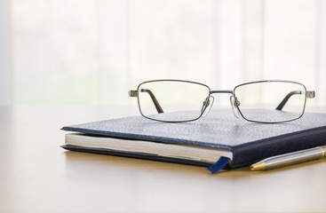 Glasses and a book on the desk