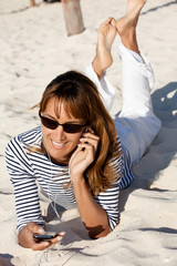 Fototapeta premium femme blonde au téléphone à la plage