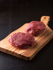 Raw Beef medallions on a wooden board