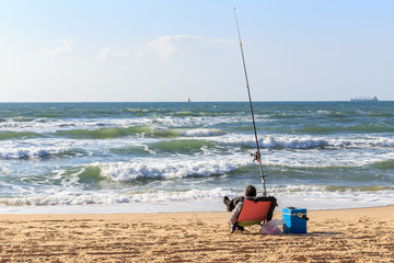 sitting man on the beach sea fishing