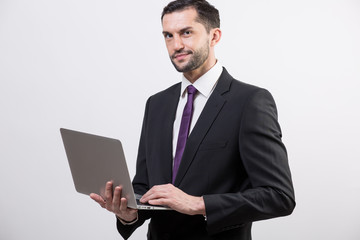 Young business man with a laptop in a studio