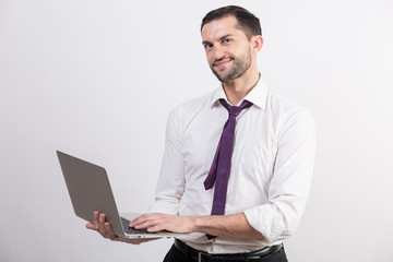 Young business man with a laptop in a studio