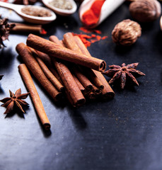 wooden spoons with spices on black background