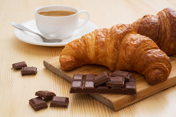Tasty croissant with chocolate and cup of coffee