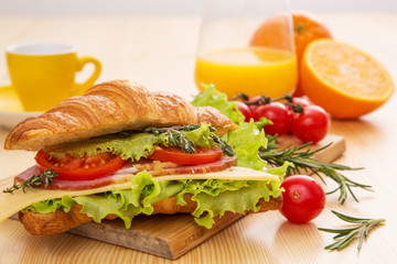 Croissant with ham, cheese, lettuce and tomato