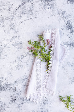 Summer day with sprig of wild grass florwer in white rustic linen napkin over stone white table. Copy space.