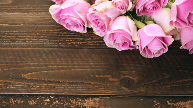 Pink roses on rustic wood table