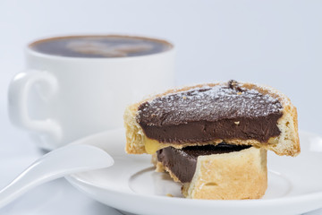 Chocolate tartlet closeup background cup of coffee