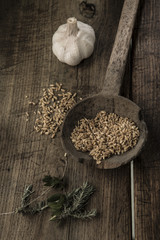 mestolo antico con grano una cipolla su un mestolo e sfondo tavola di legno scuro