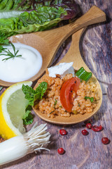 Zwei Holzlöffel mit Vorspeisen auf altem Holztisch, vertikal