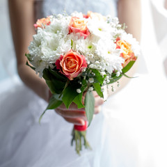 Beautiful bouquet of different colors in the hands of the bride