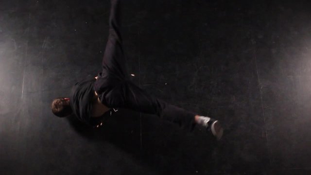 B-boy dancing breakdance in a photo studio on a black background.