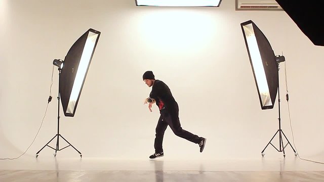 B-boy dancing breakdance in a photo studio on a white background.