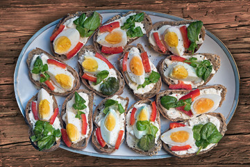 Teller mit belegten Brötchen, Remoulade, Ei, Paprika und Brunne