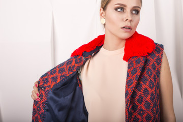 Young slim model in coat. Fashion studio shot