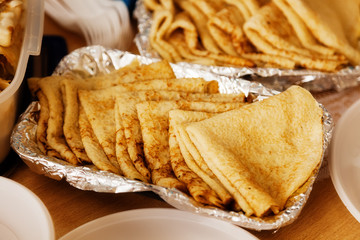 A lot of pancakes lying on the plate on the table