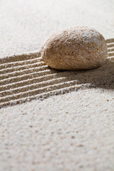 Fototapeta na wymiar zen sand still-life - textured pebble on straight lines for concept of relaxation or tranquility, closeup.